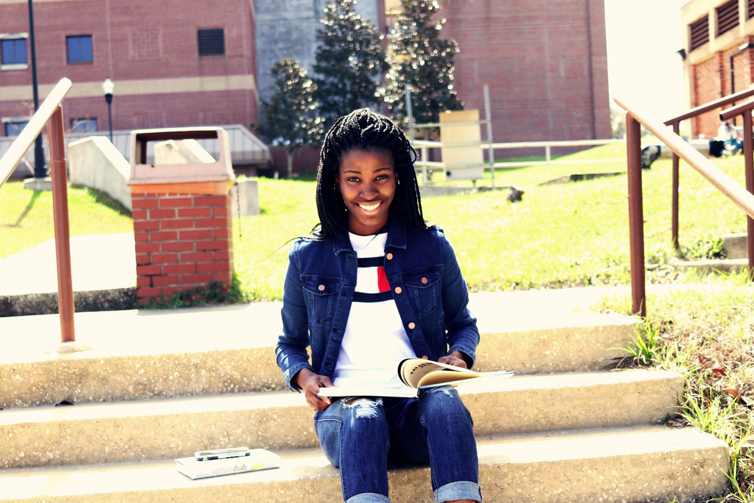 Student sitting on the steps reading Hennessy Launches $10 Million Fund For HBCU Graduate Students